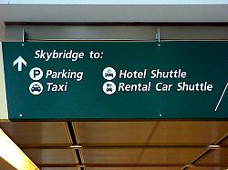 sign to  skybridge, parking, taxi, hotel shuttle and car rentals